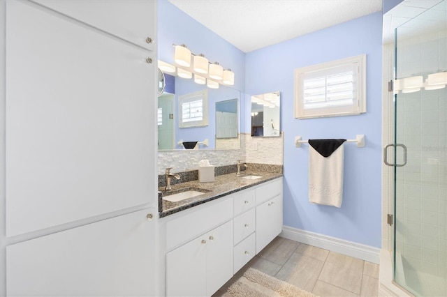 full bath with a sink, tasteful backsplash, and a stall shower