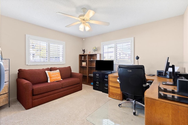 office space with light colored carpet, ceiling fan, and a textured ceiling