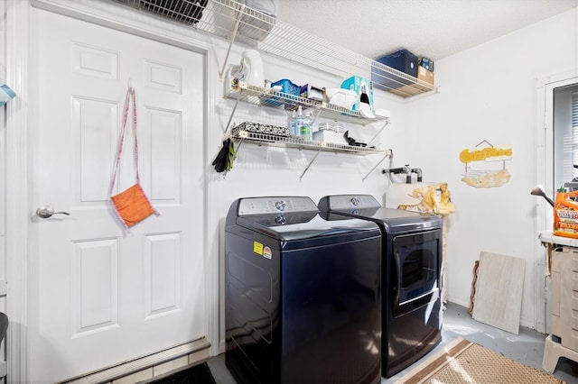 washroom featuring a textured ceiling, washing machine and dryer, and laundry area