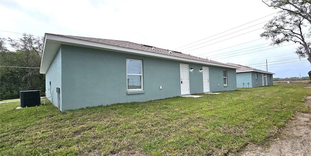 5975 NW 6th Pl, Ocala, FL 34482 - rear view of property with stucco siding, central air condition unit, and a yard