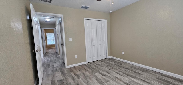 5975 NW 6th Pl, Ocala, FL 34482 - unfurnished bedroom featuring baseboards, visible vents, a closet, and wood finished floors