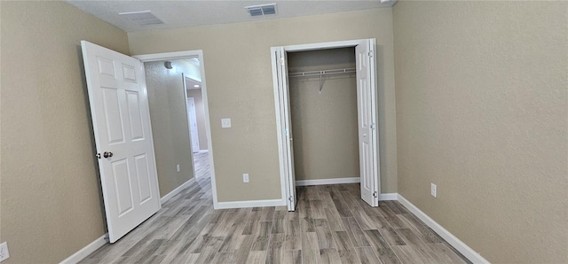5975 NW 6th Pl, Ocala, FL 34482 - unfurnished bedroom with baseboards, visible vents, and wood finished floors