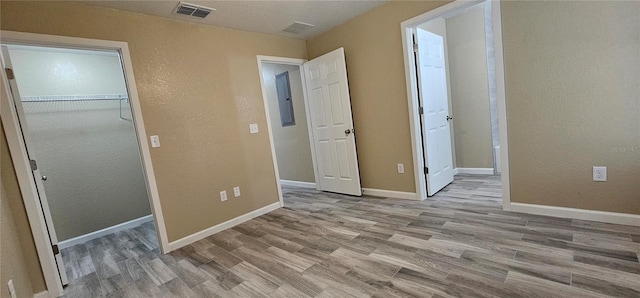 5975 NW 6th Pl, Ocala, FL 34482 - unfurnished bedroom featuring a closet, wood finished floors, baseboards, visible vents, and a textured wall