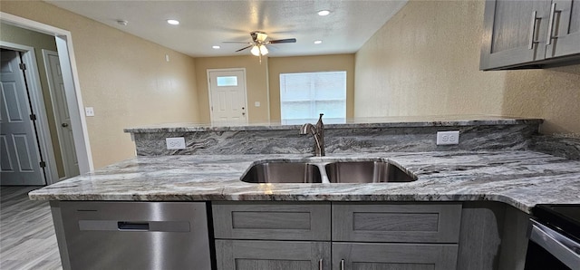5975 NW 6th Pl, Ocala, FL 34482 - kitchen featuring gray cabinetry, stainless steel dishwasher, a sink, a ceiling fan, and light stone countertops