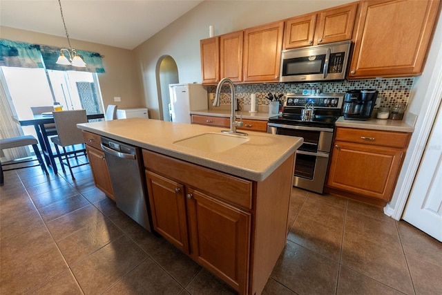 kitchen featuring backsplash, stainless steel appliances, light countertops, and a sink