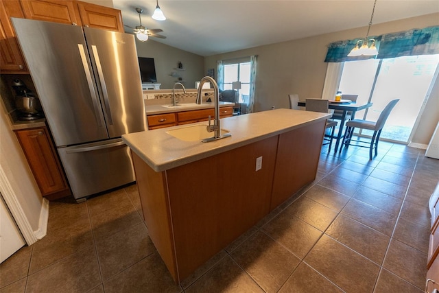 kitchen featuring a sink, freestanding refrigerator, light countertops, lofted ceiling, and hanging light fixtures