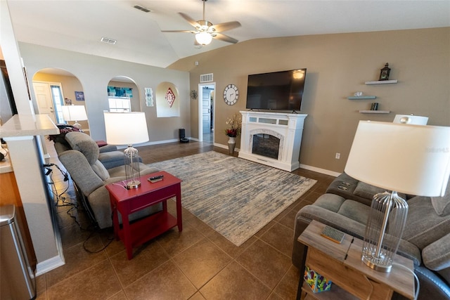 living area with lofted ceiling, a fireplace, visible vents, and arched walkways