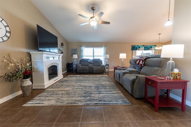 tiled living area with a fireplace, a ceiling fan, baseboards, and vaulted ceiling