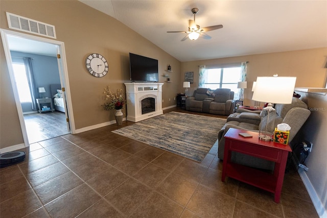 living area with visible vents, a fireplace, baseboards, ceiling fan, and vaulted ceiling