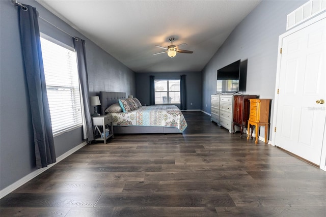 bedroom with lofted ceiling, baseboards, visible vents, and dark wood-style flooring