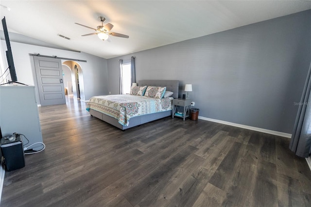 bedroom featuring arched walkways, visible vents, a barn door, and wood finished floors