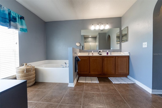 full bathroom with baseboards, a sink, a shower stall, tile patterned floors, and a bath