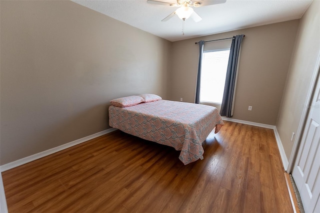 bedroom with light wood-type flooring, baseboards, and a ceiling fan