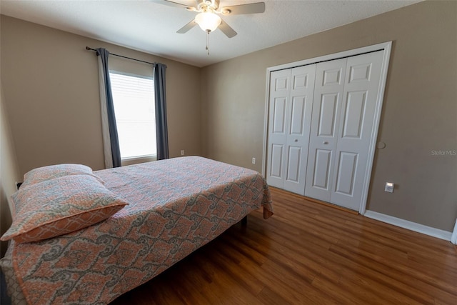 bedroom with a closet, ceiling fan, baseboards, and wood finished floors