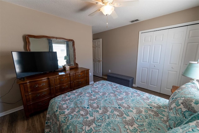 bedroom with wood finished floors, visible vents, baseboards, ceiling fan, and a closet