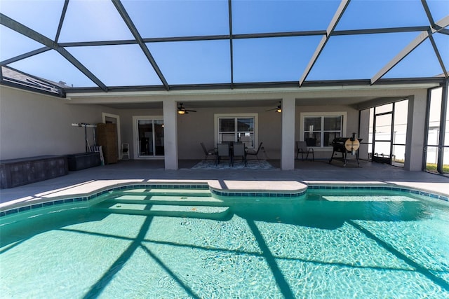 outdoor pool with a lanai, a patio area, and ceiling fan