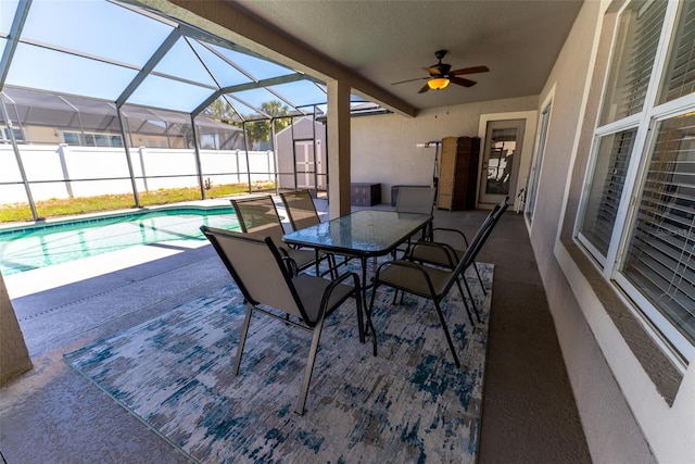 view of patio / terrace with a fenced in pool, a lanai, a ceiling fan, and outdoor dining space