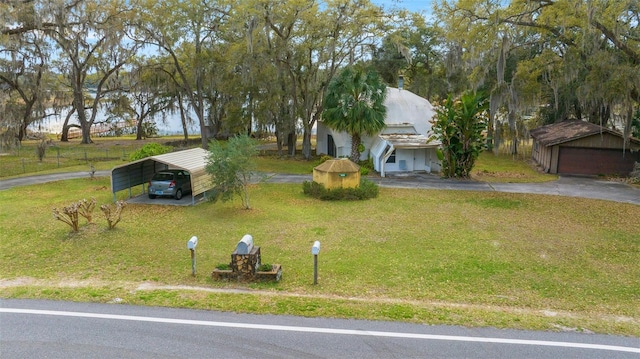 exterior space featuring a carport, driveway, and an outdoor structure