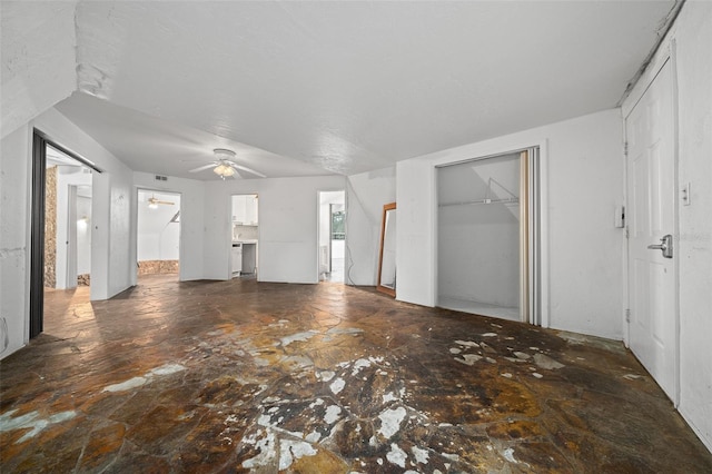 unfurnished living room featuring a ceiling fan