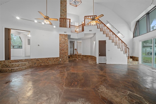 unfurnished living room featuring stairway, visible vents, a towering ceiling, and a ceiling fan