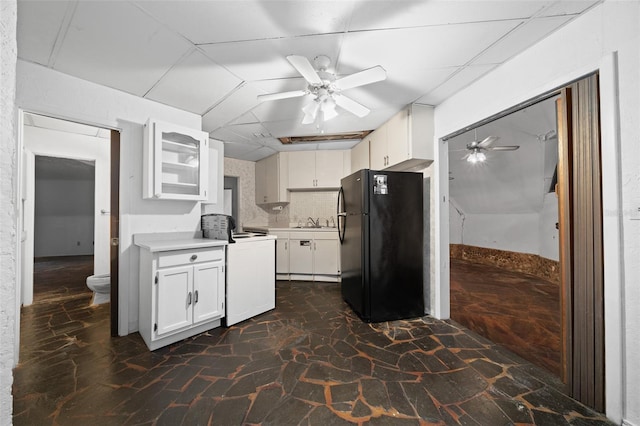 kitchen featuring a ceiling fan, freestanding refrigerator, a sink, light countertops, and white cabinetry