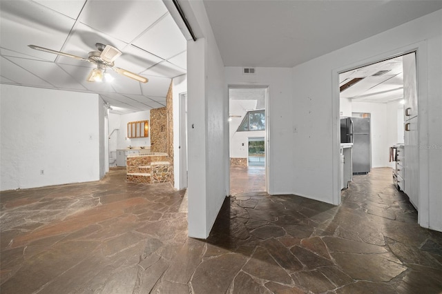 hall with visible vents and stone flooring