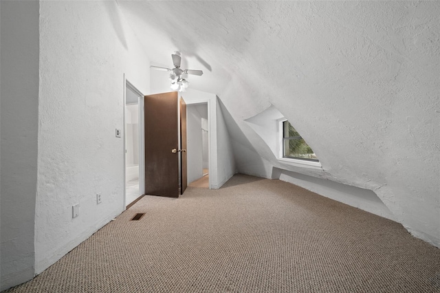 additional living space featuring lofted ceiling, a textured ceiling, carpet, and a textured wall