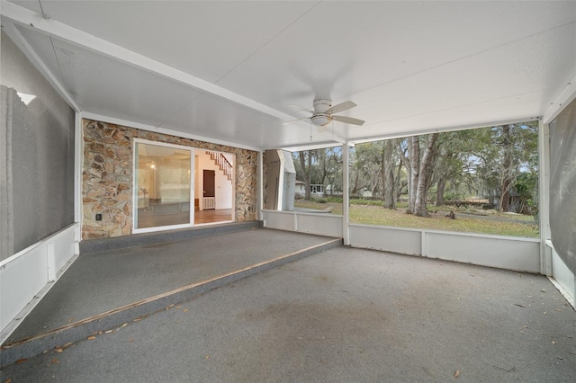 unfurnished sunroom with ceiling fan