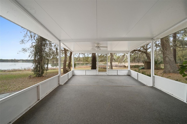 unfurnished sunroom with a ceiling fan and a water view