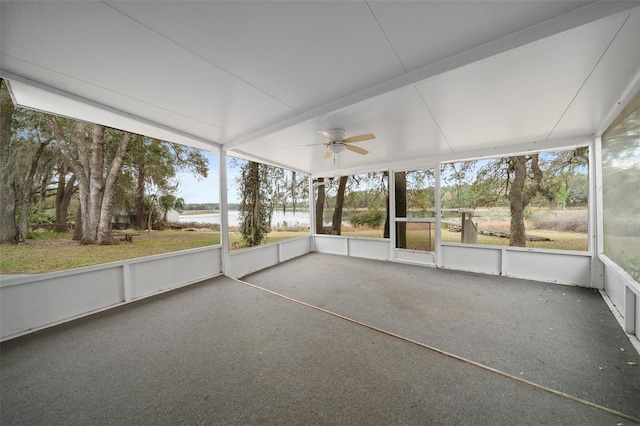 unfurnished sunroom featuring a water view and a ceiling fan