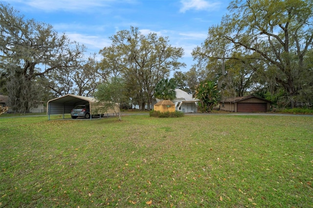 view of yard featuring a garage and a detached carport