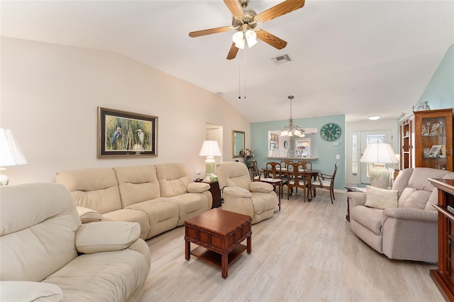 living area featuring visible vents, baseboards, lofted ceiling, light wood-type flooring, and ceiling fan with notable chandelier