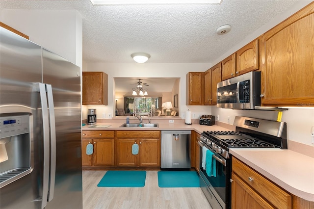 kitchen featuring a sink, stainless steel appliances, and brown cabinetry