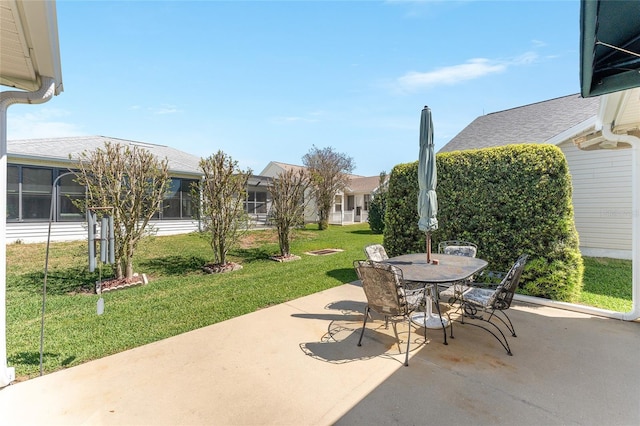 view of patio featuring outdoor dining area and a sunroom