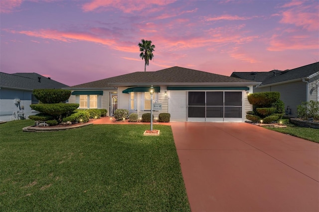 ranch-style home with a lawn, a garage, and concrete driveway