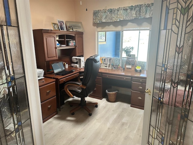 office space featuring built in study area and light wood-style floors