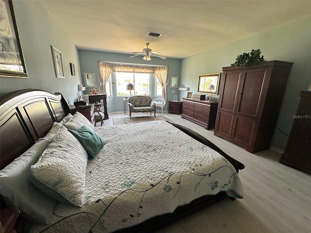 bedroom with visible vents, a textured ceiling, baseboards, and ceiling fan