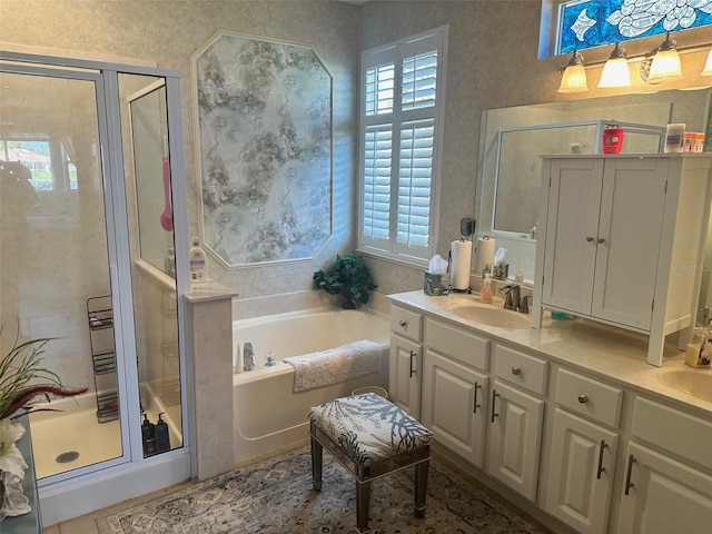 full bath with a sink, double vanity, a bath, and a shower stall