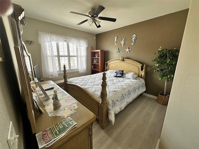 bedroom featuring light wood-type flooring, baseboards, and a ceiling fan