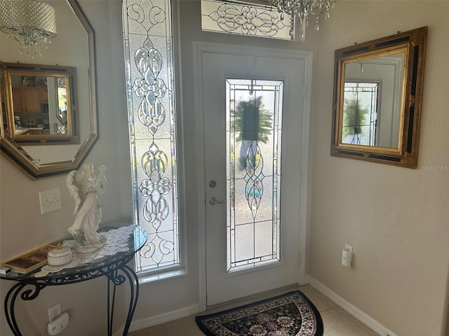 entryway with baseboards and a notable chandelier