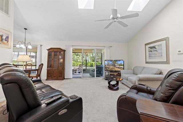 carpeted living room featuring vaulted ceiling with skylight, ceiling fan with notable chandelier, and visible vents