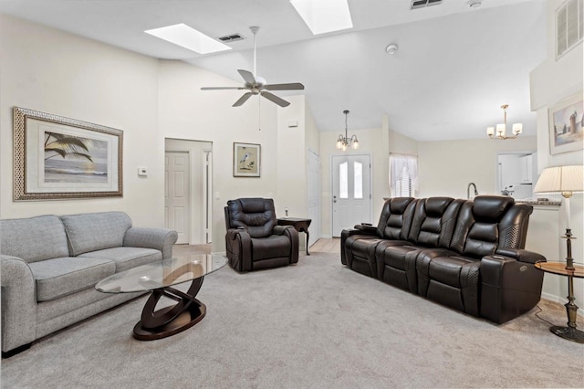 carpeted living room with a skylight, visible vents, and high vaulted ceiling