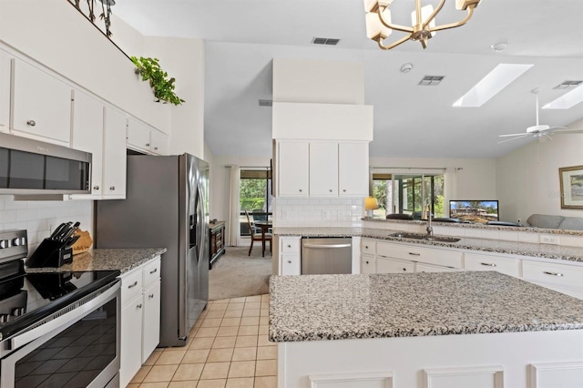 kitchen with a wealth of natural light, white cabinets, appliances with stainless steel finishes, and a sink