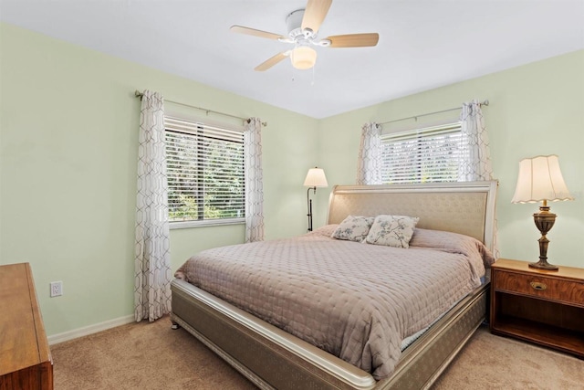 carpeted bedroom featuring multiple windows, baseboards, and ceiling fan