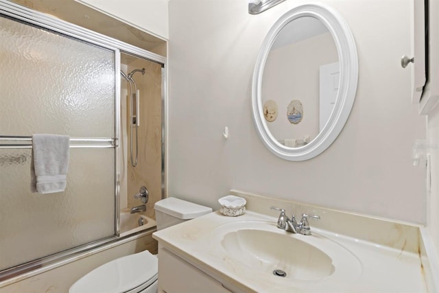 bathroom featuring vanity, toilet, and shower / bath combination with glass door