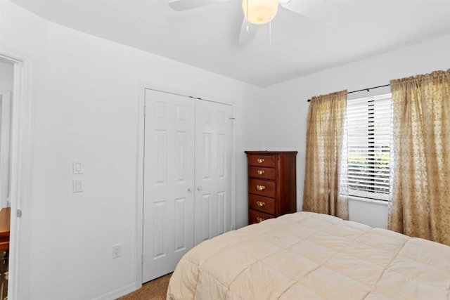 carpeted bedroom featuring a closet, baseboards, and a ceiling fan