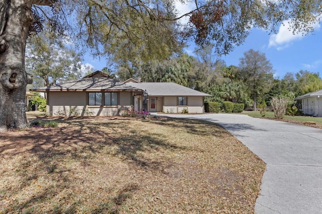 ranch-style house with a front yard and driveway