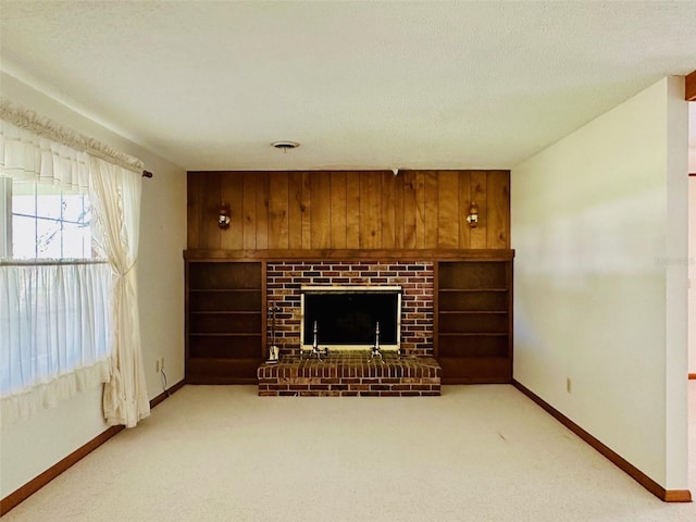 unfurnished living room featuring a textured ceiling, a fireplace, light colored carpet, and baseboards