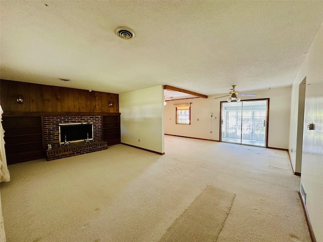 unfurnished living room with baseboards, visible vents, a textured ceiling, a brick fireplace, and light colored carpet