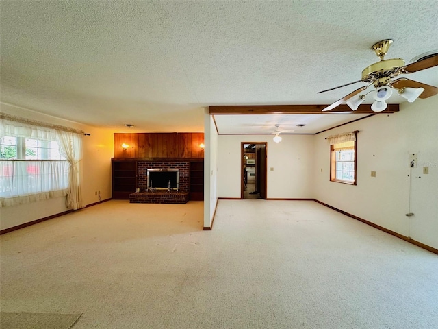 unfurnished living room with ceiling fan, a brick fireplace, a textured ceiling, and baseboards